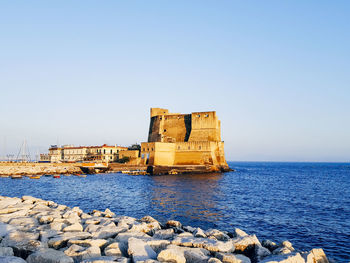 Built structure on sea shore against clear sky