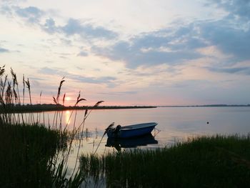 Boats in sea at sunset