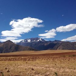 Scenic view of landscape and mountains against blue sky