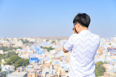 Rear view of teenage girl looking at cityscape