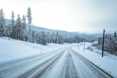 Snow covered road against sky