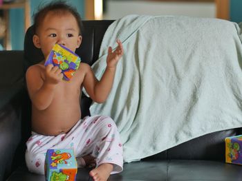 Portrait of cute baby girl sitting at home