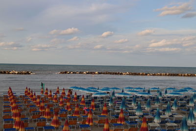 Chairs on beach against sky