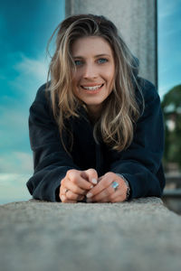 Portrait of a smiling young woman sitting outdoors