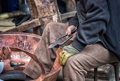 Midsection of man working with copper 