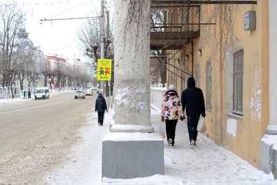 Rear view of people walking in city