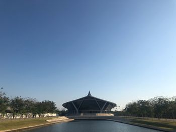 Building on field against clear blue sky