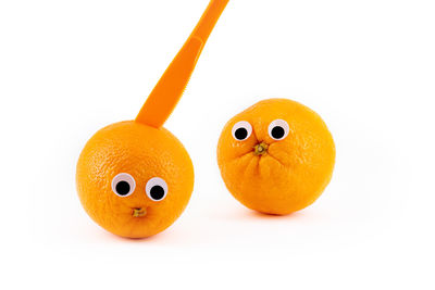 Close-up of orange fruit against white background