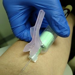 Close-up of hand against blue sky