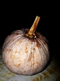 Close-up of pumpkin on table against black background