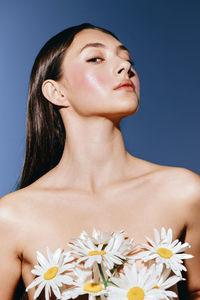 Close-up of young woman with flowers