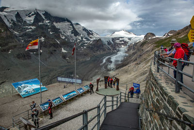 People on snowcapped mountain against sky