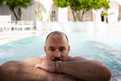 Man relaxing in pool on vacation in riyadh, morocco