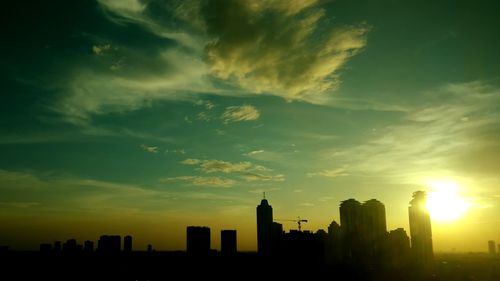 Silhouette buildings against sky during sunset