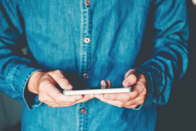 Midsection of man using mobile phone