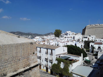 High angle view of townscape against blue sky on sunny day