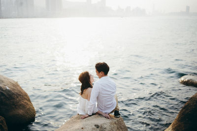 Rear view of couple sitting on beach