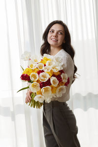 Portrait of young woman holding bouquet