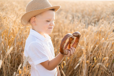 Portrait of young woman wearing hat standing on field