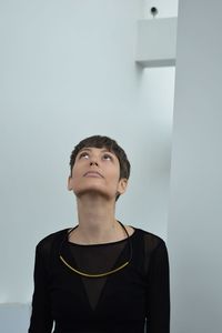 Portrait of young man looking away against wall