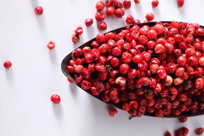 Close-up of red fruits in bowl on white background