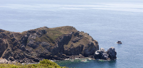 High angle view of cliff by sea against sky