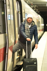 Portrait of man with luggage entering in train