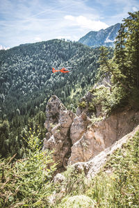 Airplane flying over mountains against sky