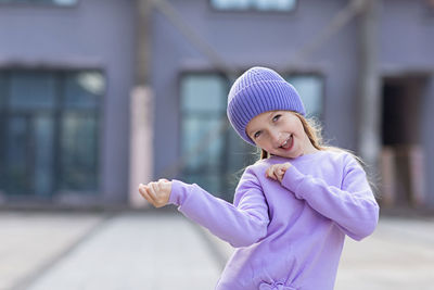 Portrait of cute girl gesturing while standing outdoors