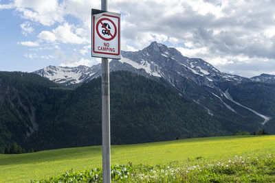 A no camping sign with a view in the background of monte bivera from the village sauris di sopra,