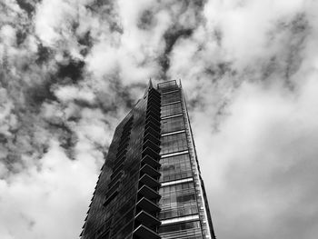 Low angle view of modern buildings against cloudy sky