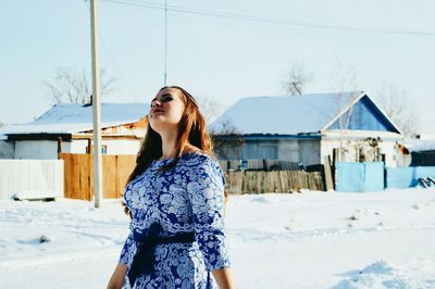 Woman in house against sky during winter