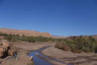 Scenic view of desert against clear blue sky