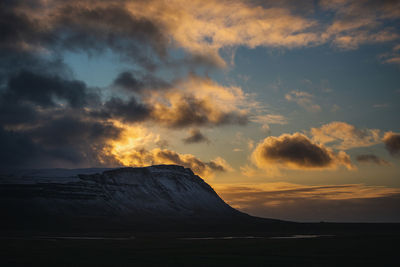 Scenic view of sea against dramatic sky during sunset