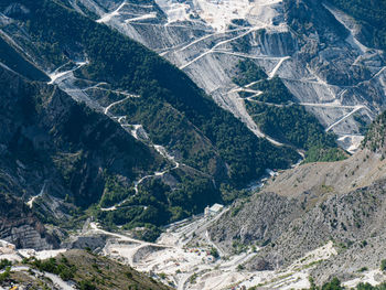 View of the carrara marble quarries and the transport trails carved into the side of the mountain.