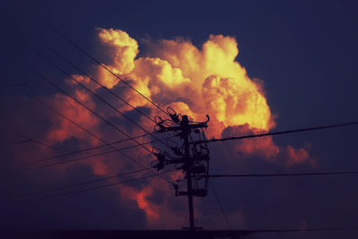 Low angle view of silhouette electricity pylon against sky during sunset