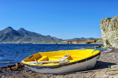 Yellow moored on beach against clear blue sky in la isleta, cabo de gata