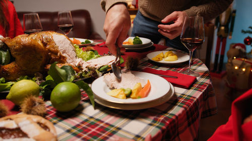 Man preparing and serving roasted turkey for thanksgiving