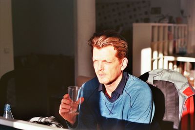 Young thoughtful man drinking water