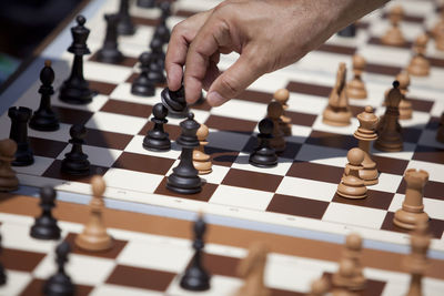 Cropped hand of man playing chess on table