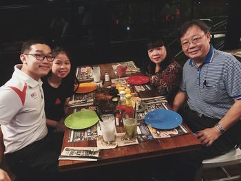 Portrait of family smiling while sitting at restaurant