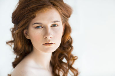 Close-up portrait of young woman against white background