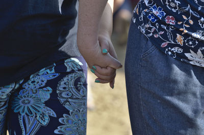 Midsection of couple holding hands