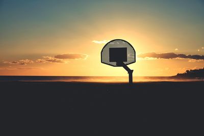 Silhouette basketball hoop against sky during sunset