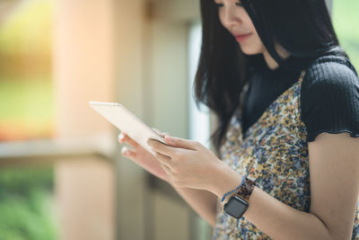 Midsection of woman using digital tablet