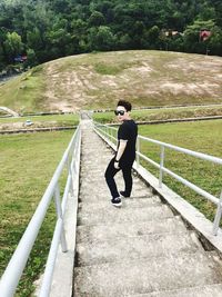 Full length portrait of man walking on steps on hill