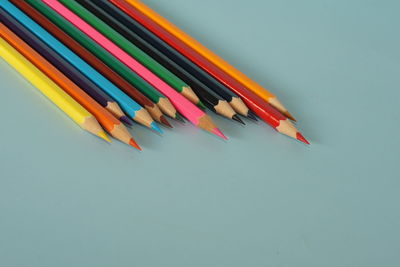 High angle view of colored pencils against white background