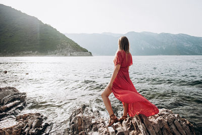 Midsection of woman in mountains against sky