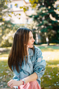 Worried woman looking away while sitting at park