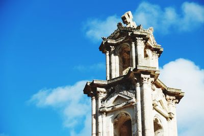 Low angle view of clock tower against blue sky